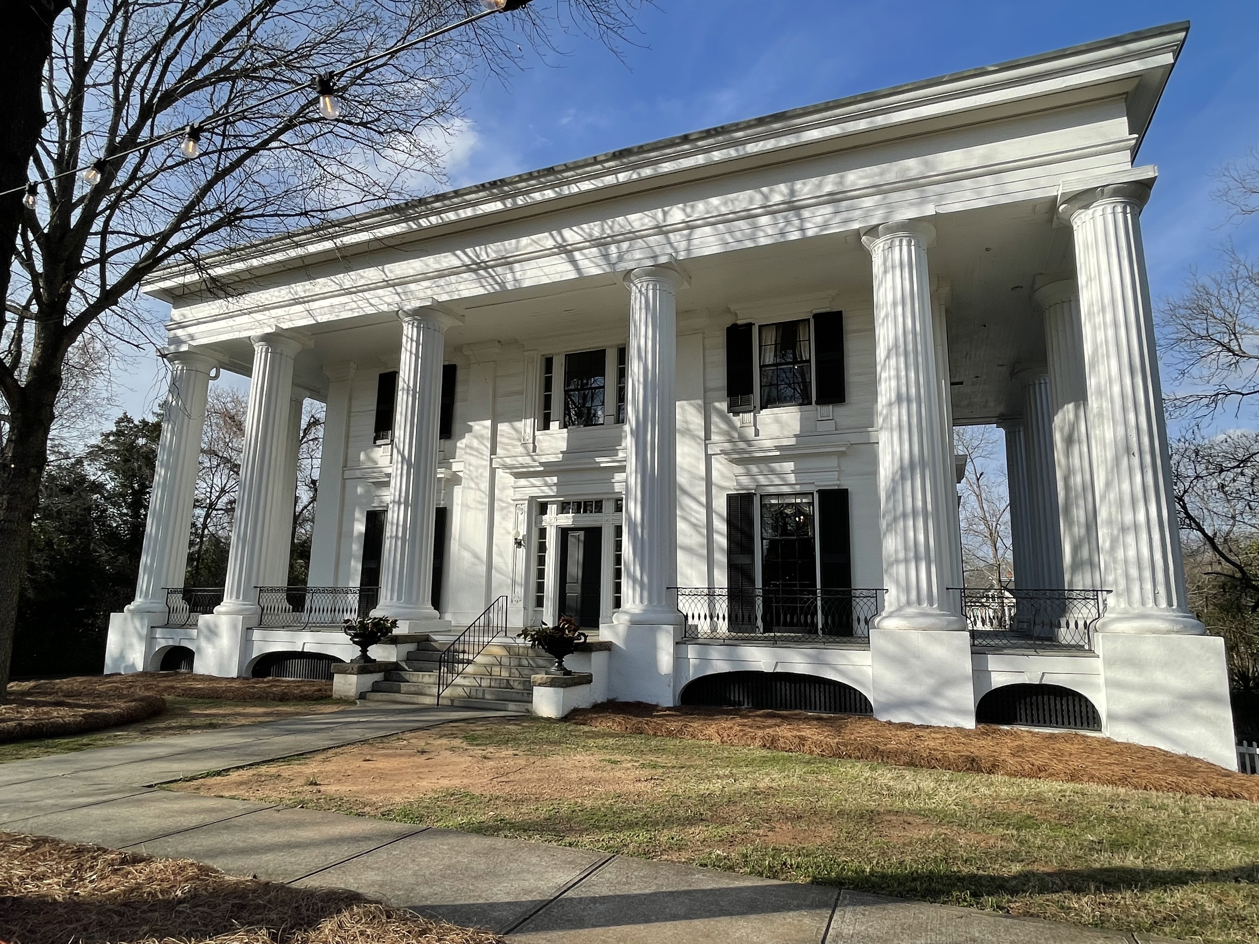 Front facade of Taylor-Grady House showing Greek Revival columns, wrought iron railings, and stone steps in Athens Georgia