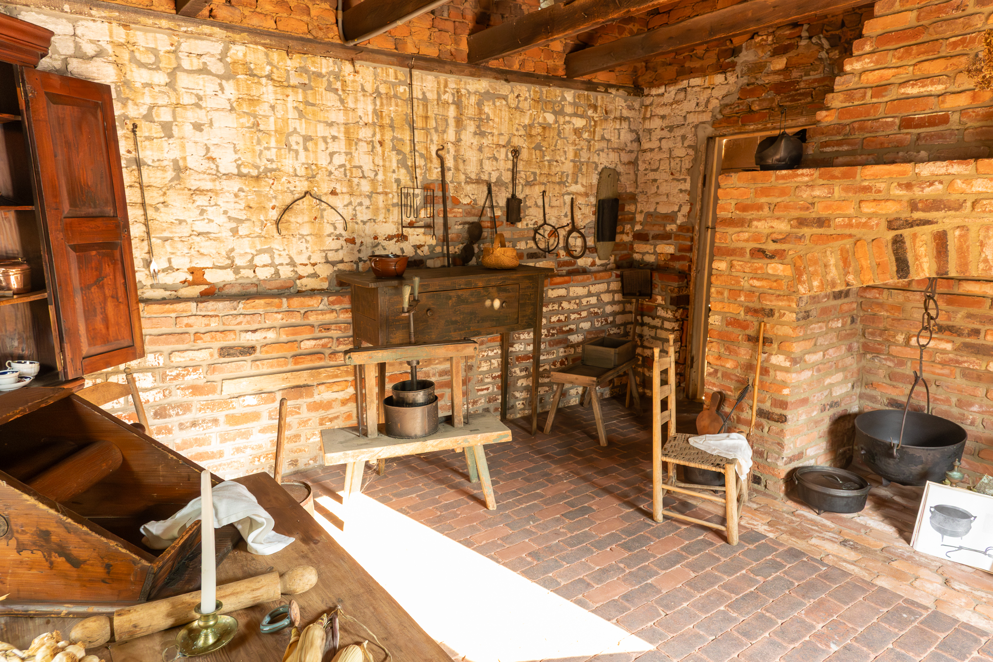 Historic kitchen interior with brick hearth, cast iron cookware, and period tools at Taylor-Grady House, Athens Georgia